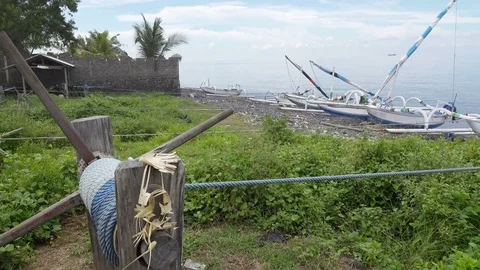 BALI, INDONESIA OCTOBER 2016: Tradichionny boats of fishermen on seashore and Stock Footage