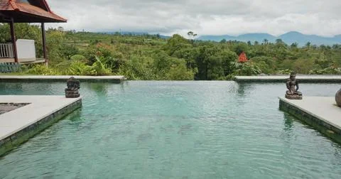 Bali infinity pool looking over tropical landscape and mountains Stock Photos