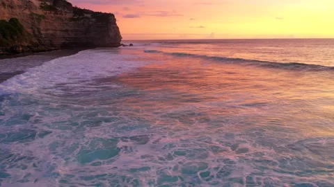 Bali - waves hitting coral reef and rocky cliffs. Sunset over the ocean. Stock Footage 134620034