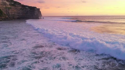 Bali - waves hitting coral reef and rocky cliffs. Sunset over the ocean. Stock Footage 134620163