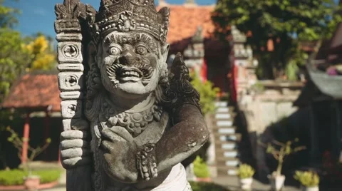 Balinese man stone statue in front of balinese gates and fountain, slide Stock Footage 68083985