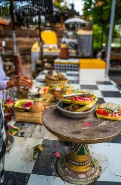 Balinese offerings on a rustic table, featuring vibrant food and woven craf.. Stock Photos