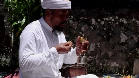 Balinese priest ringing a bell and performs the ritual of remembrance Stock Footage 159334728