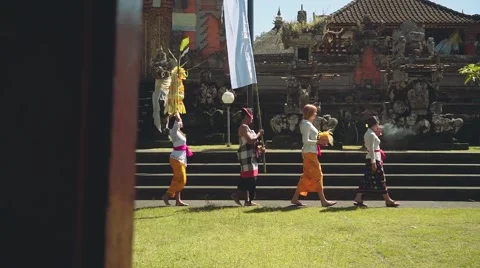 Balinese procession going to temple with offerings, umbrella and white flag Stock Footage 67851749