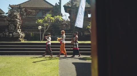 Balinese procession going to temple with offerings, umbrella and white flag Video stock 67851752