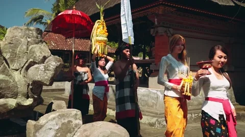 Balinese procession going to temple with offerings, umbrella and white flag Stock-Footage 67851823