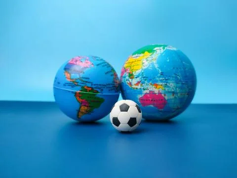 Ball is between globes on a blue Stock Photos