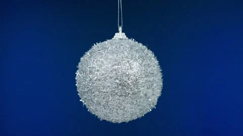 Ball on blue background. Silver New Year's toy rotates around its axis, macro ph Stock Footage 227718580