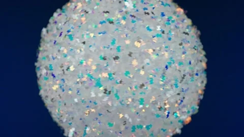 Ball on blue background. Silver New Year's toy rotates around its axis, macro ph Stock Footage 227720211