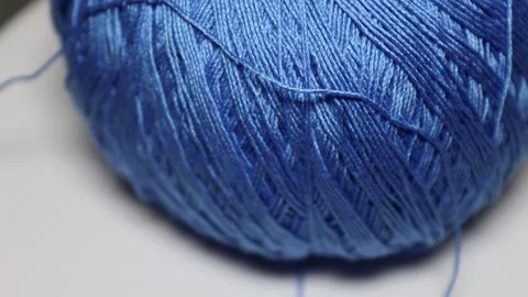 A ball of blue yarn sits on a table, ready for use in crafting or knitting Видео 337048027