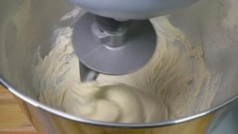 A ball of bread dough quickly being turned in an automatic mixer bowl. Video stock 170445551