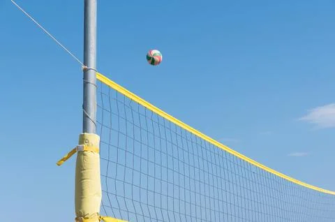 The ball flies through the net against the background of clear blue sky, beach Stock Photos