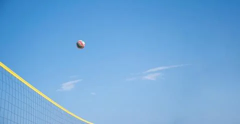 The ball flies through the net against the background of clear blue sky, beach Stock Photos