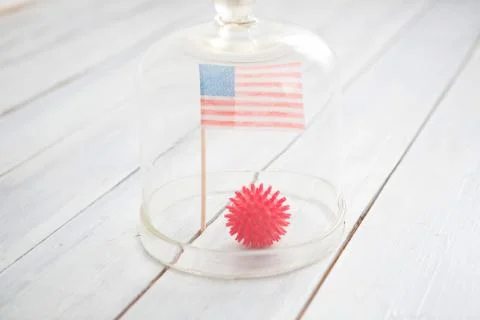Ball in the form of a model of coronavirus Covid-19 and the US flag under a g 스톡 사진
