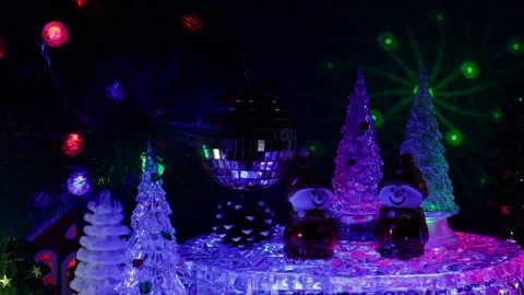 A ball hanging on a Christmas tree surrounded by Christmas trees and snowmen Stock Footage 333568507