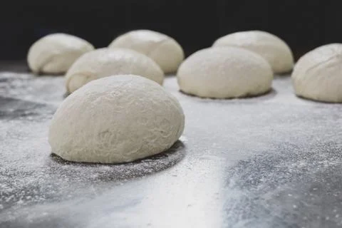 Ball of pizza dough on table with dusting of flour. Stock Photos
