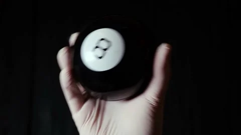 Ball of predictions figure eight in hand in a glove on a black background. Stock Footage 147931927
