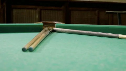 Ball rolling down two cues, hitting white ball into pockets on billiard table 4K 库存影片 109411840