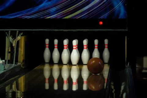 Ball rolling on the right side a bowling alley lane with pins Stock Photos