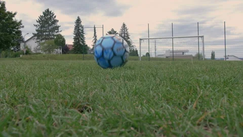 Ball rolling towards an empty goal at a low perspective Stock Footage 153378296