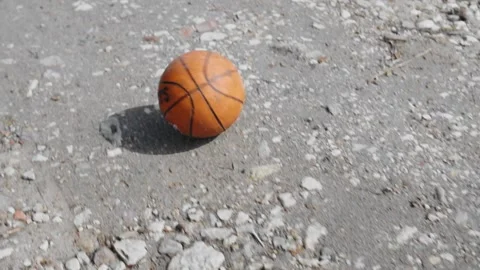 The ball rolls down an old dirt road down a hill. The camera follows the ball Stock Footage 130540730