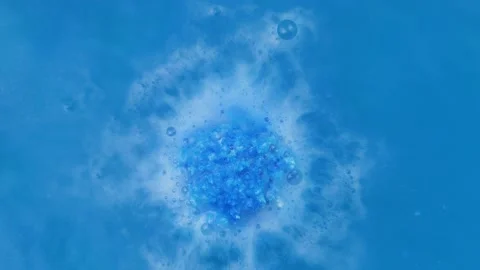Ball of salt dissolves in water. blue bath bomb Stock Footage 164126362
