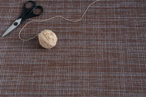 A ball with thick threads and scissors on the table. Stock Photos