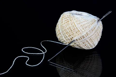 Ball of thread and needle, sewing design background. Stock Photos