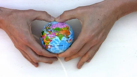 Ball with the world drawn in hands placed in the shape of a heart Stock Footage 105011803