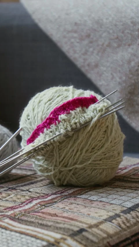 Ball of Yarn with Knitting Needles on Sofa at Home Stock Footage 304108647