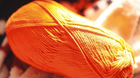 A ball of yarn resting on a table surface, waiting to be used for knitting .. Stock Footage 332225044