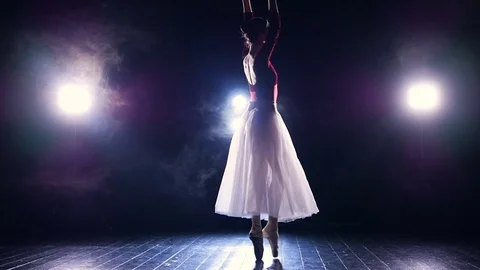 A ballerina balances and turns in the dark. Stock Footage