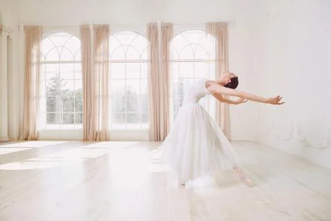Ballerina dancing in a studio on background window. Stock-Fotos