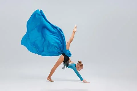 Ballerina performs an acrobatic move, balancing on her hands with a leg ele.. Stock Photos