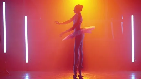 Ballerina is practicing elements in studio with warm colorful light. Young woman Video stock 154945974