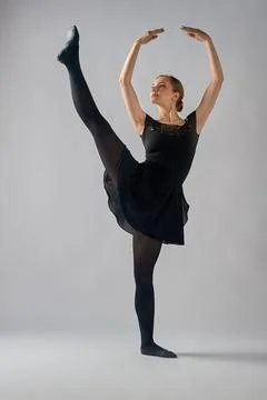 Ballerina stands in a pose a la seconde on a white background Stock Photos