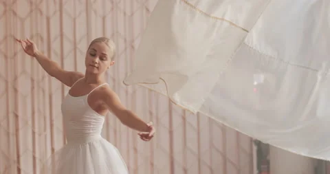 A ballerina in a white ballet suit performs various ballet moves Stock Footage 150984076