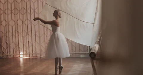 A ballerina in a white ballet suit performs various ballet moves Stock Footage 150984137