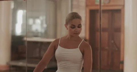 A ballerina in a white ballet suit performs various ballet moves Stock Footage 150984206