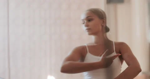 A ballerina in a white ballet suit performs various ballet moves Stock Footage 150984233