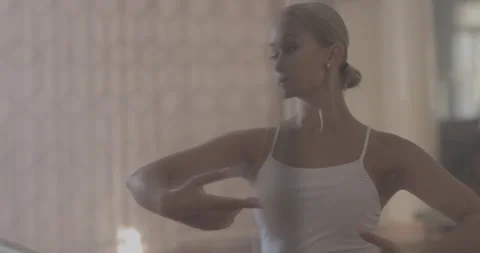 A ballerina in a white ballet suit performs various ballet moves Stock Footage 150984434