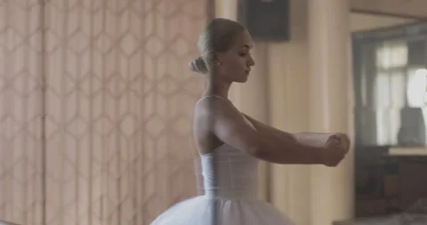 A ballerina in a white ballet suit performs various ballet moves Stock Footage 150984466