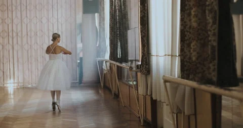 A ballerina in a white ballet suit performs various ballet moves Stock Footage 150984467