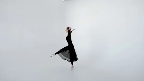 A ballet dancer in black elegantly dances in a white ballet class slow motion Stock Footage 77219775