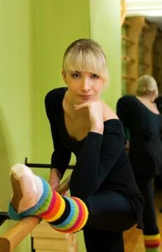 Ballet dancer doing exercise near the bar Stock Photos