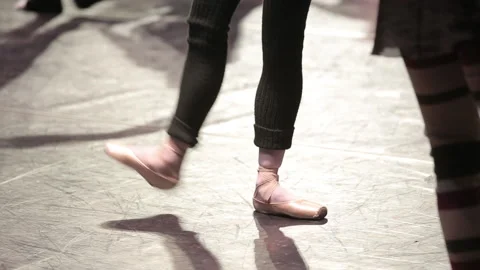 Ballet dancer is doing exercises at the ballet barre among other dancers Stock Footage 93822913
