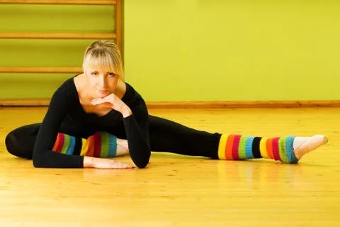 Ballet dancer doing stretching exercise on a floor Stock Photos