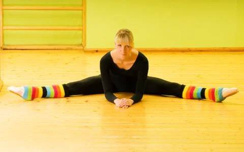 Ballet dancer doing stretching exercise on a floor Stock Photos