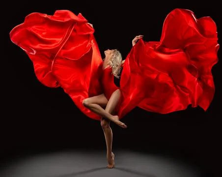 Ballet Dancer jumping with Red Silk Fabric flying on Wind over Black Stock Photos