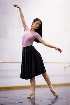 Ballet dancer performs in a studio wearing a pink top and black skirt during a Stock Photos